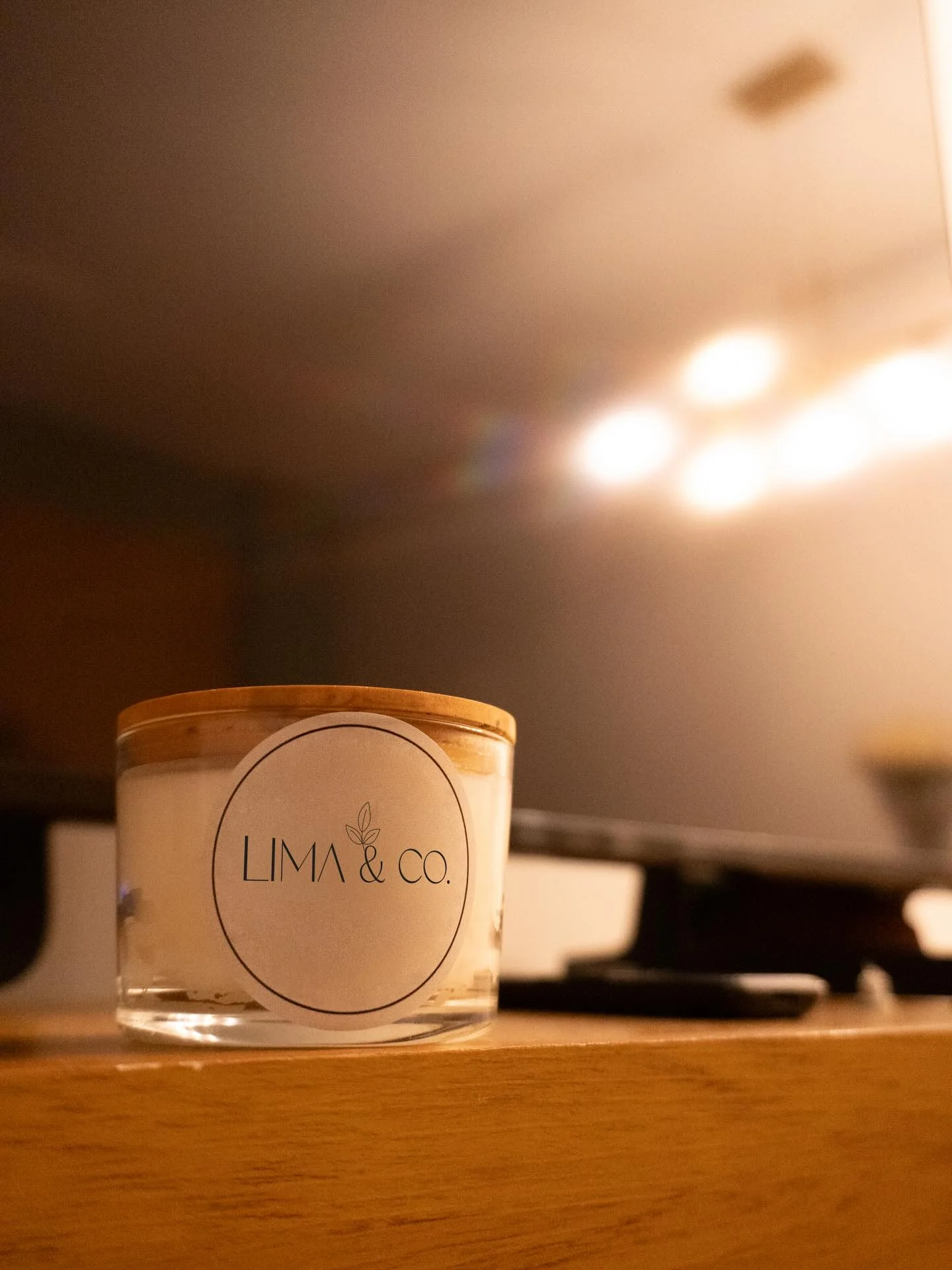 Vela Lima & Co. acesa numa mesa, com luzes desfocadas ao fundo