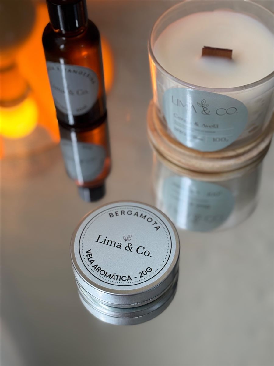 Mini vela Bergamota, vela de 100g e difusor Lima & Co. sobre uma mesa espelhada